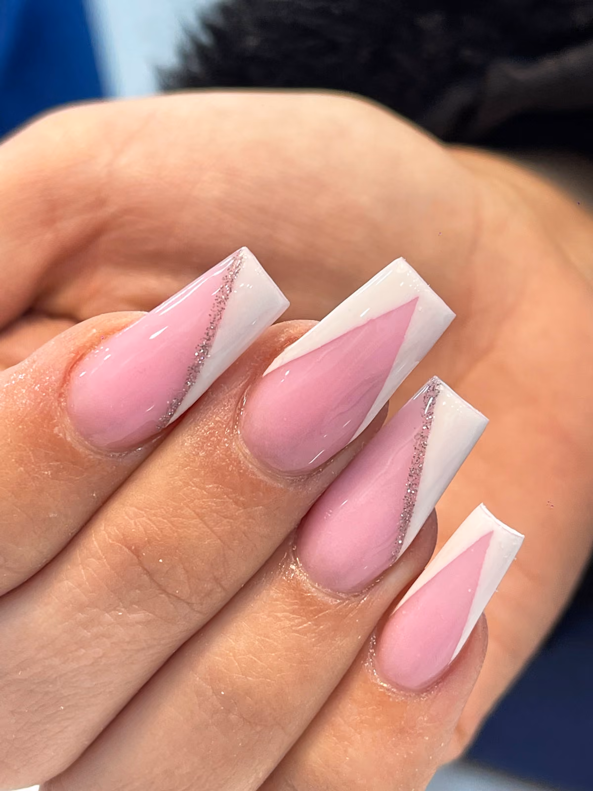 Pink acrylic nails with white diagonal tips and a glitter line